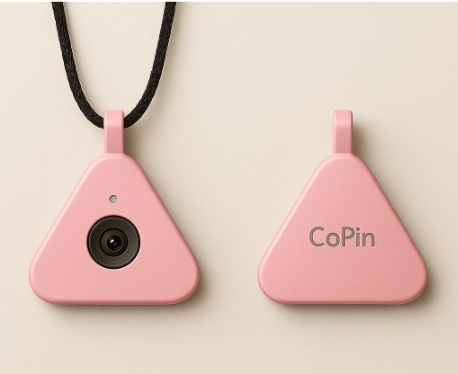 An image of Copilot's latest creation, the CoPin. It's a triangle shaped piece of metal with a pink coating and a camera in the front.